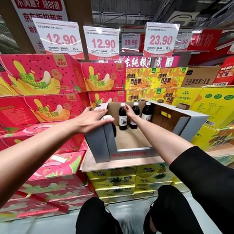 First-person human demonstration arranging bottles in a display box, from the paper's internal egocentric dataset